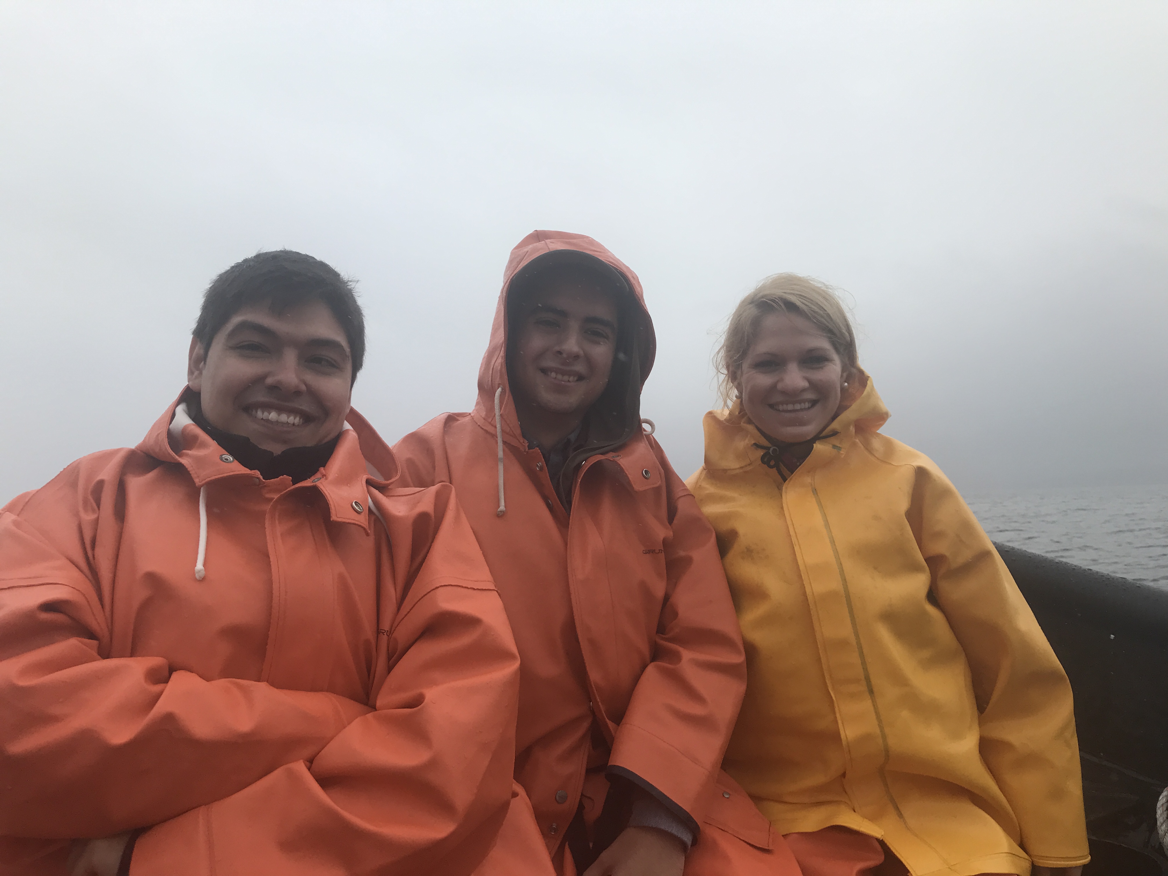 Amy Kinsley on a salmon boat with two other Chilean researchers